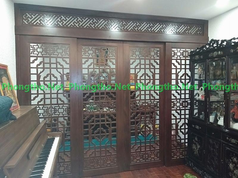 Kệ vách ngăn phòng khách được bố trí hợp phong thủy, với cây xanh và vật phẩm trang trí mang ý nghĩa tốt lành